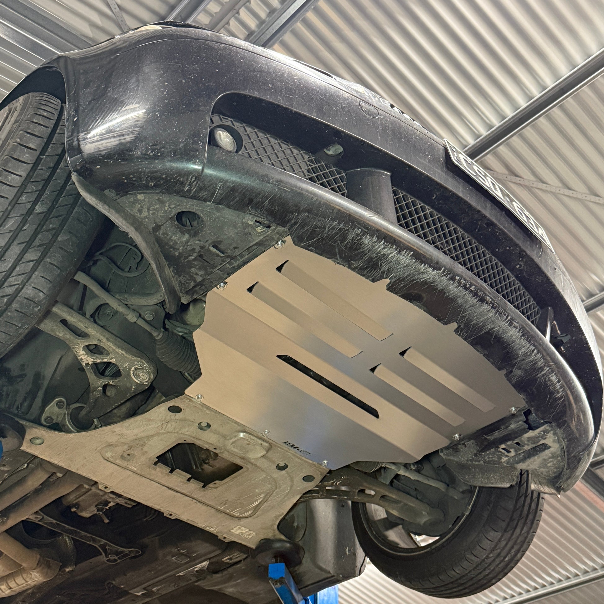 BMW E46 on a lift in a garage setting with an aftermarket aerocutt undertray installed