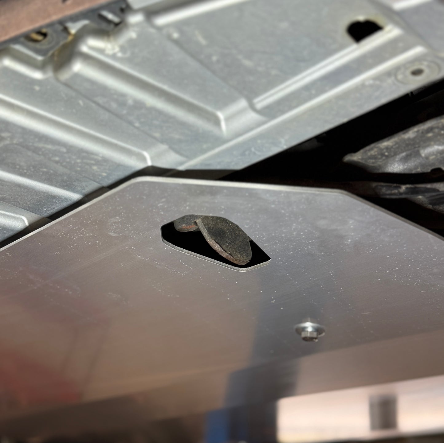 Close-up of a metal bracket with a bolt on a textured surface, aerocutt towpoint access ports 