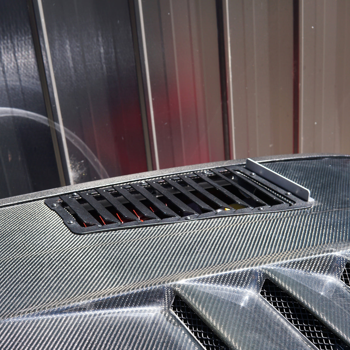 Carbon fibre bonnet on nissan race car with aerocutt bonnet vents installed for cooling