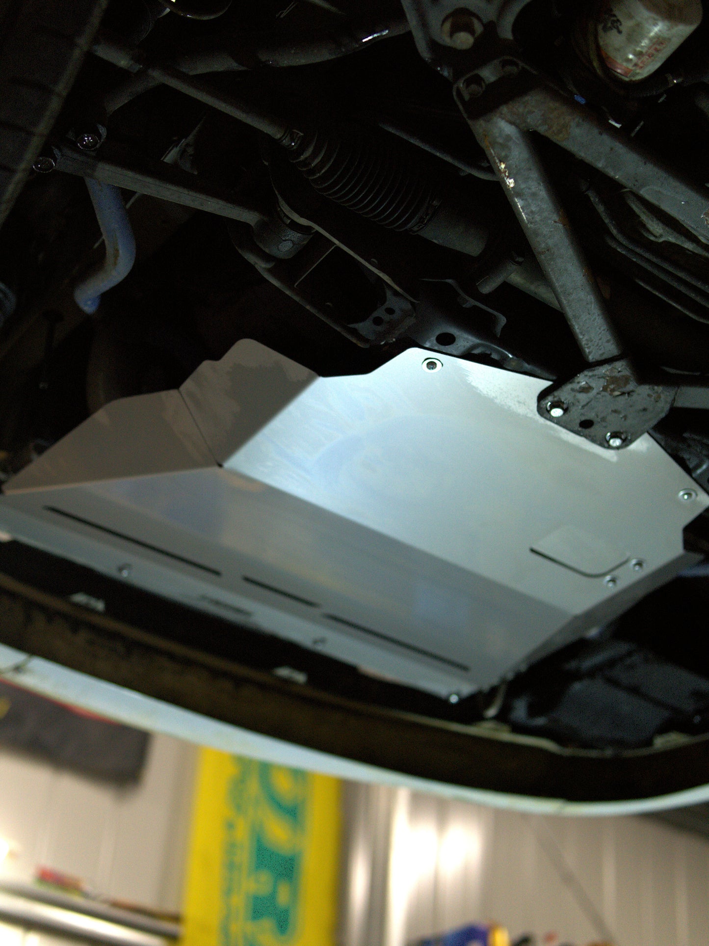 Close-up of a JZX100 chaser cresta mark 2 undercarriage with an aluminium aerocutt skid tray sump guard