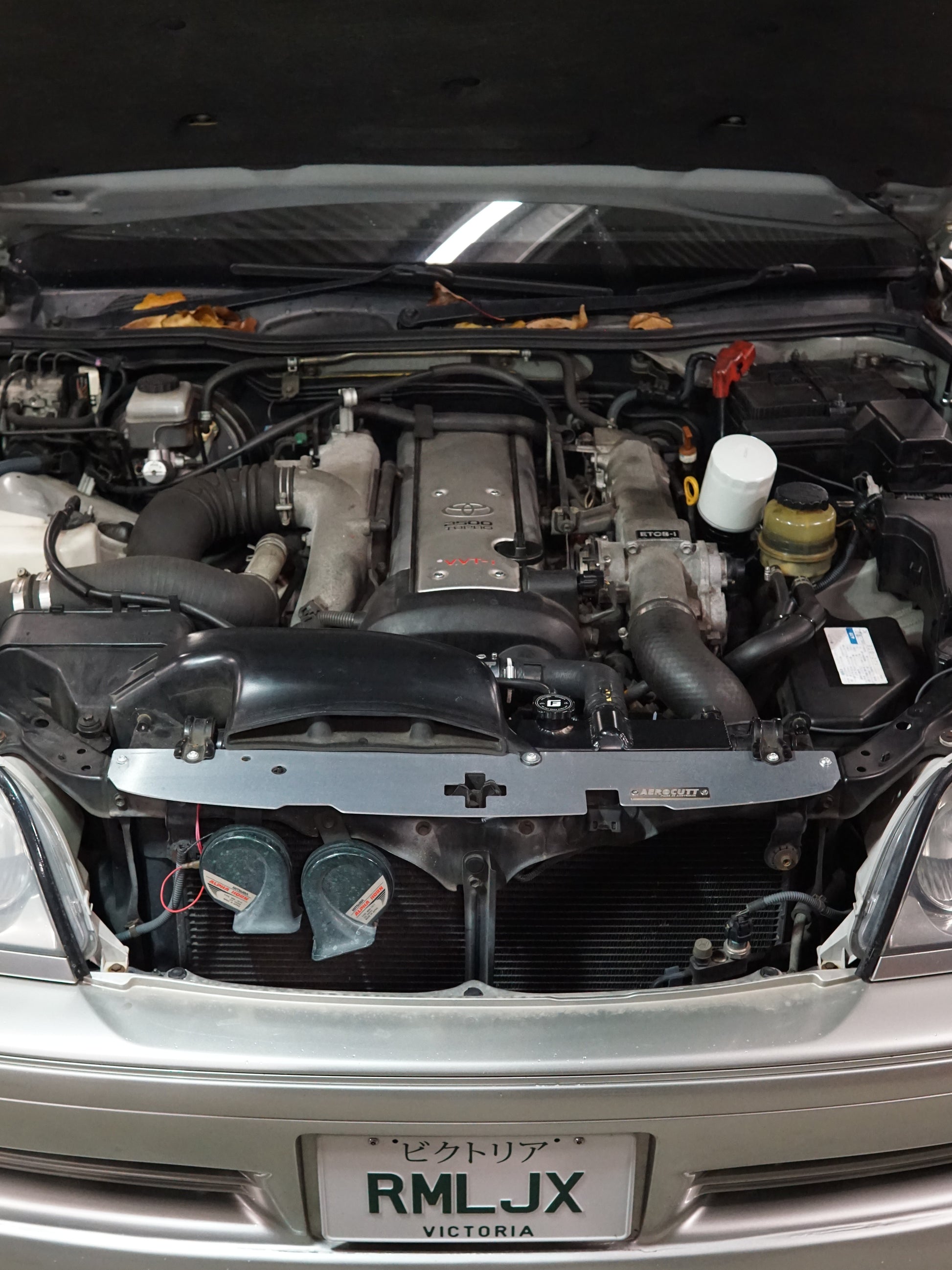 Toyota Crown JZS171 engine bay with Aerocutt Aluminium Radiator Cooling Panel installed and laser etched logo plate