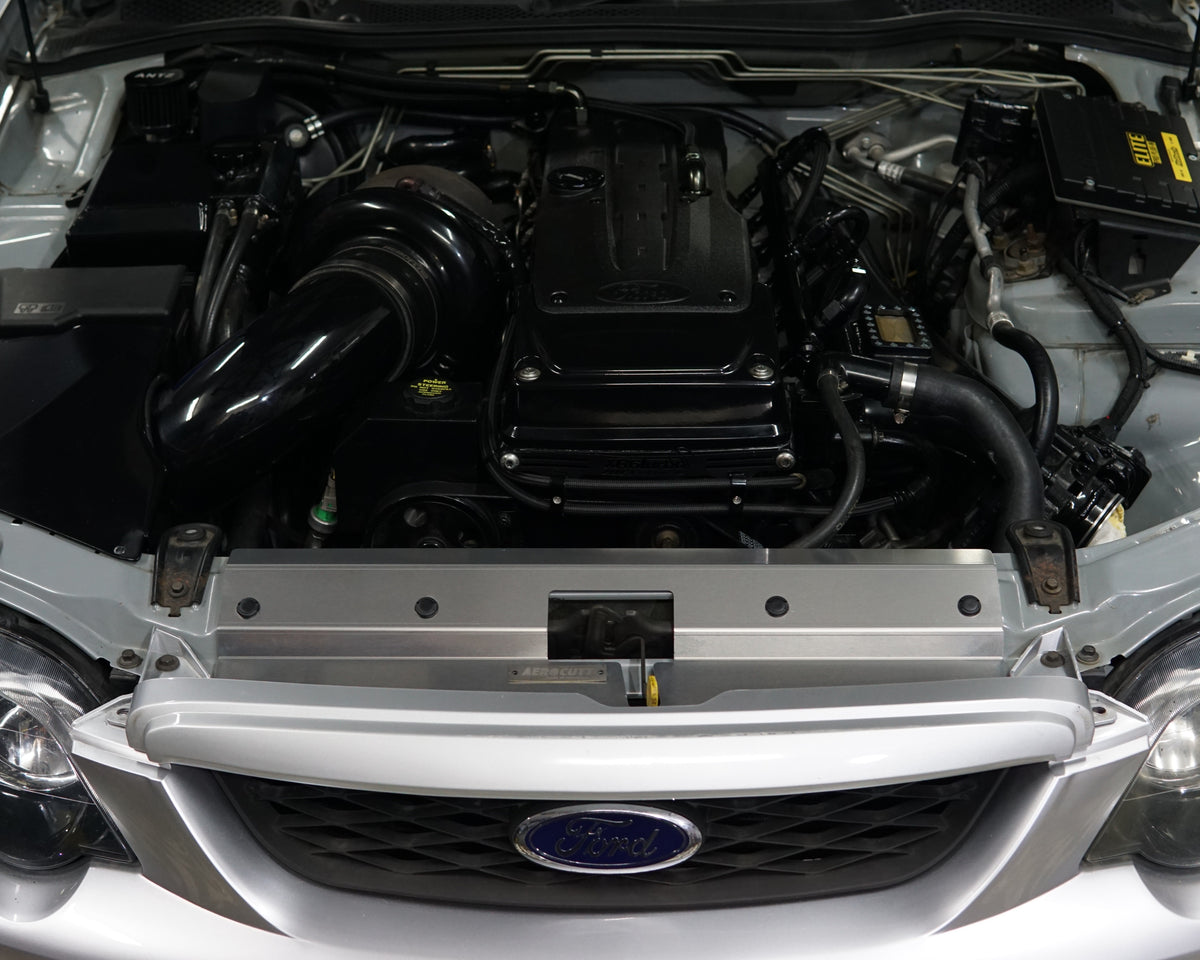 A close up of a Ford Falcon BA/BF engine bay with an Aerocutt aluminium replacment air diversion plate/cooling panel
