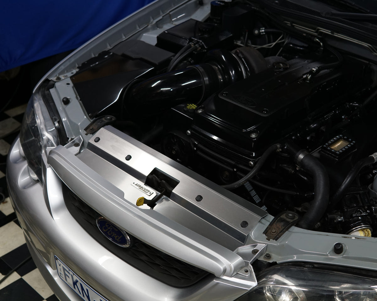 A close up of a Ford Falcon BA/BF engine bay with an Aerocutt aluminium replacment air diversion plate/cooling panel