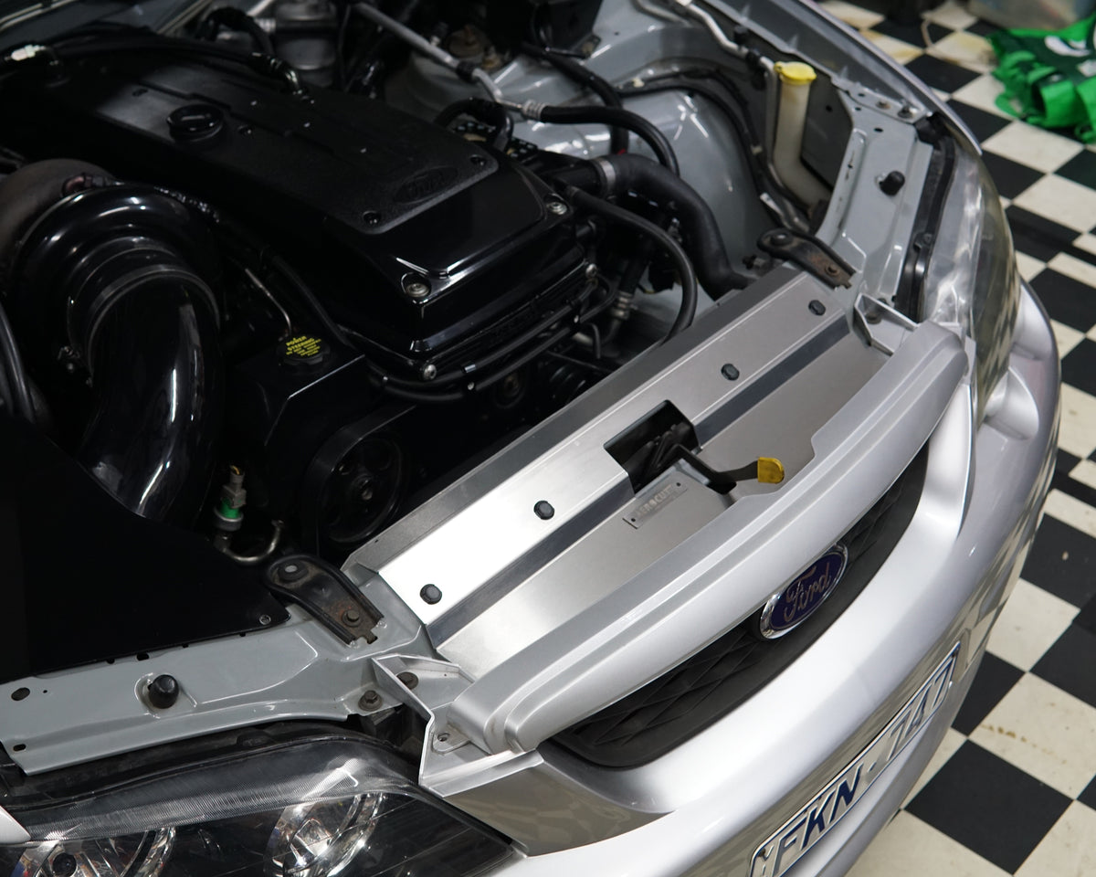A close up of a Ford Falcon BA/BF engine bay with an Aerocutt aluminium replacment air diversion plate/cooling panel