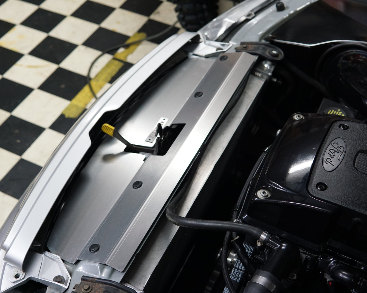 A close up of a Ford Falcon BA/BF engine bay with an Aerocutt aluminium replacment air diversion plate/cooling panel