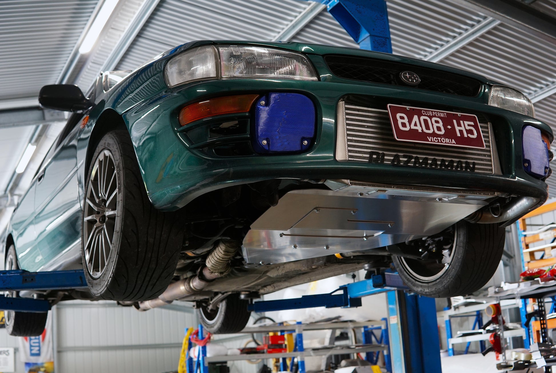 gc8 on a lift in a garage with visible license plate & bash plate