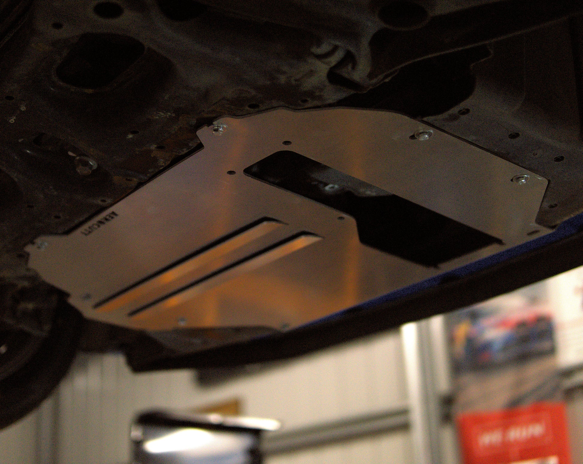 Metal undercarriage guard on a honda jazz fit gk in a garage setting