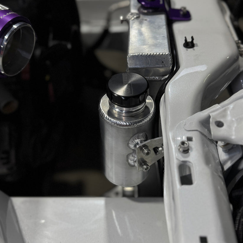 Nissan Silvia s13/180sx engine bay with Lazaro Motorsports overflow bottle mounted in raw aluminium
