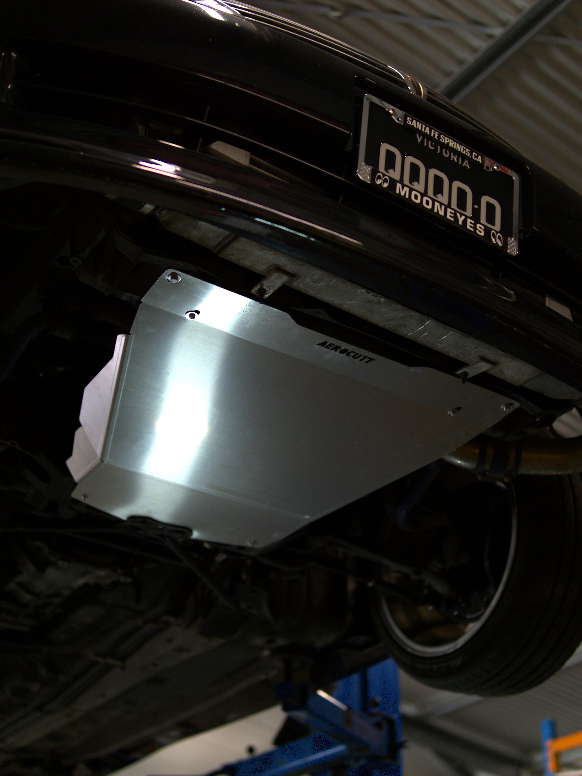 Undercarriage of a vehicle with a metal护板in a garage setting