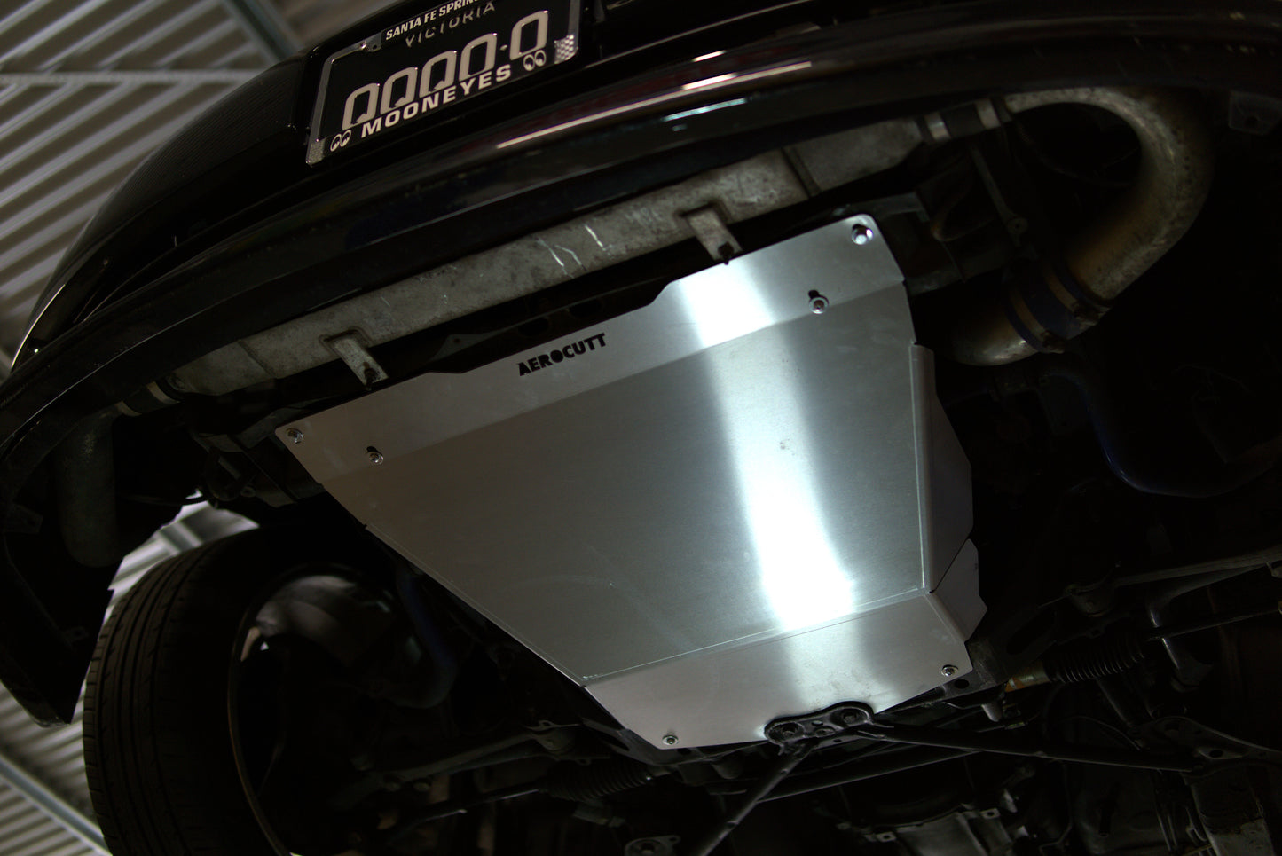 Close-up of a car's undercarriage with a metal guard, brand 'Aerocutt' visible.